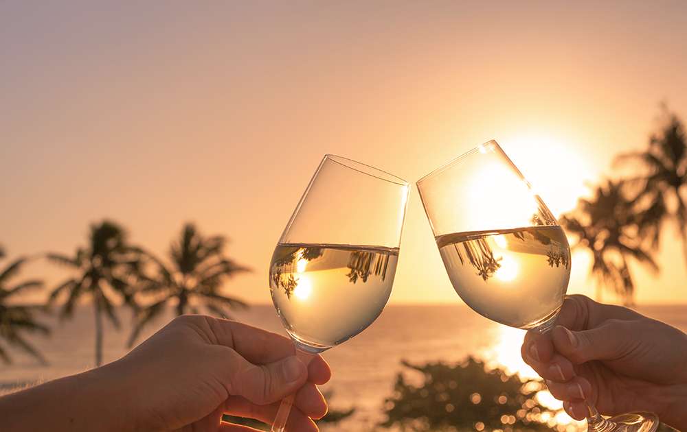 Cheers with wine glasses in a beautiful sunset setting